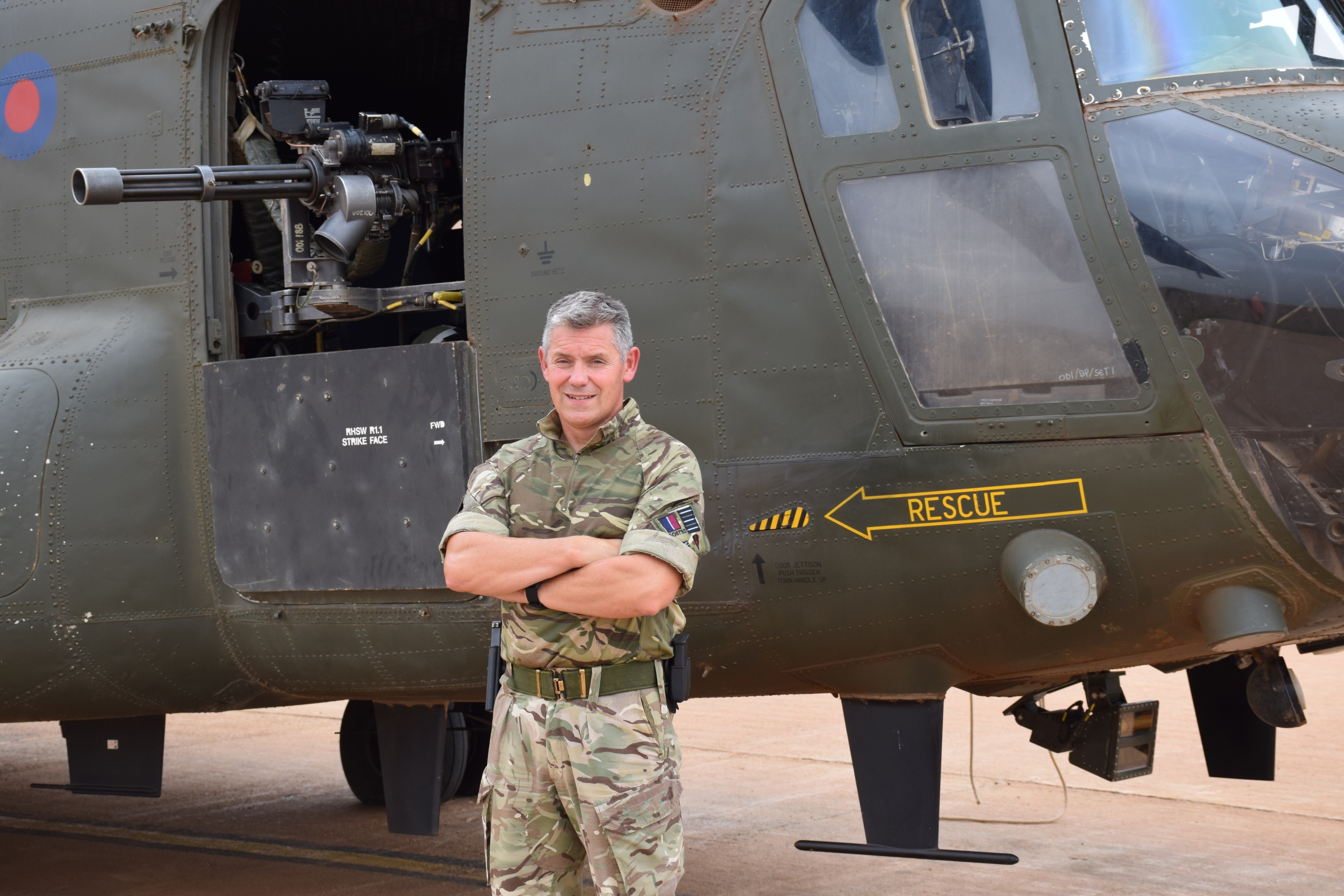 Wing Commander Sommers stands in-front of a Chinook.